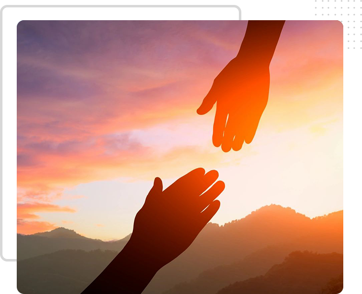 Two hands reaching out towards each other in the sunset.