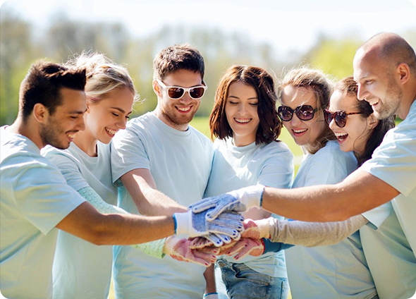 A group of people in white shirts holding hands.